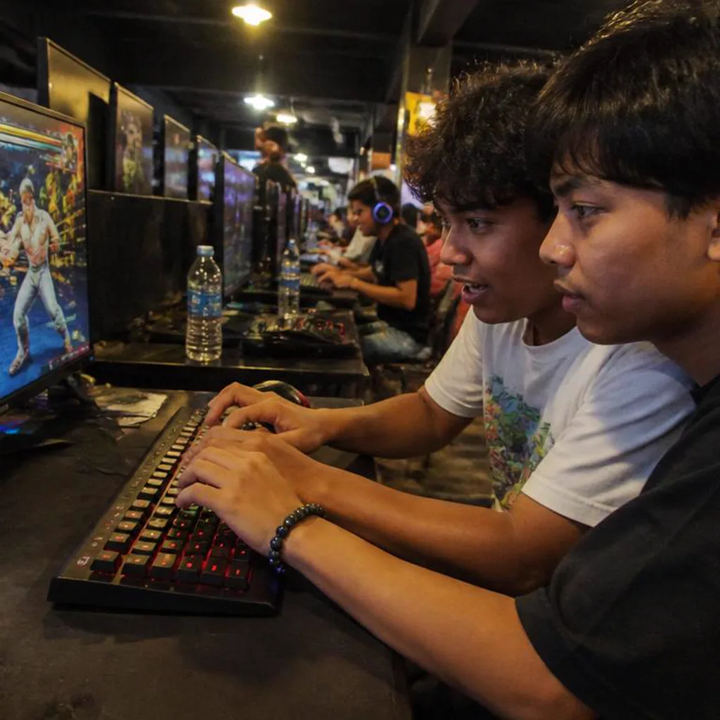 Two players side by side at a shared duo desk mid-match